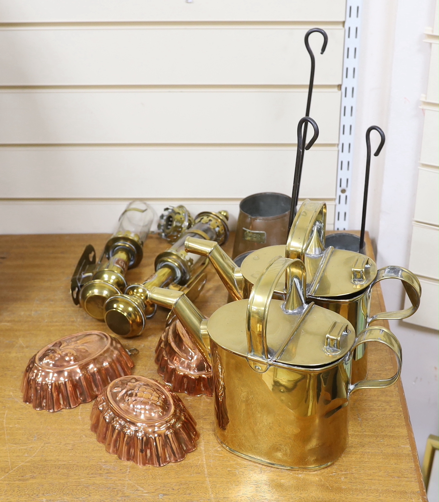 Two brass watering cans, two brass GWR carriage lamps, three copper Cider measures and three copper jelly moulds, GWR lights 36cm high